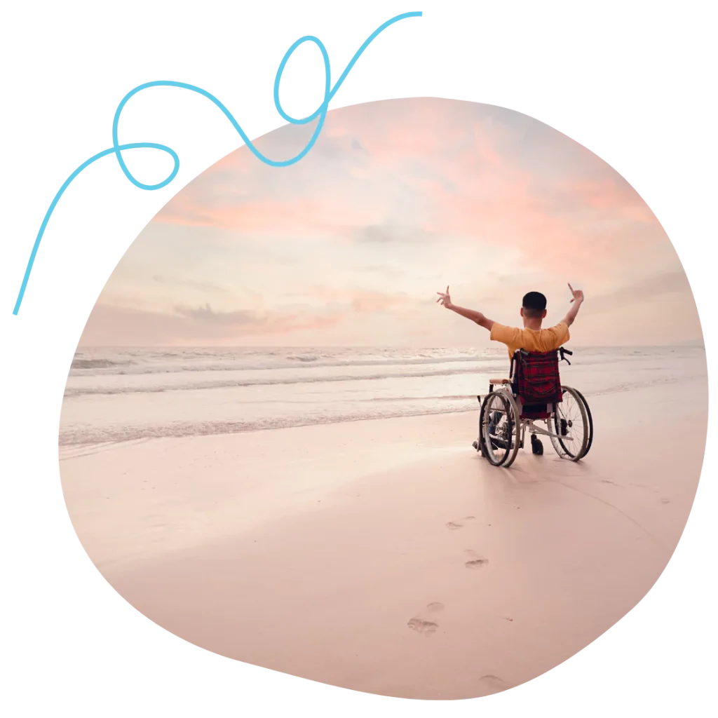 A disabled man sitting in his wheelchair at the beach